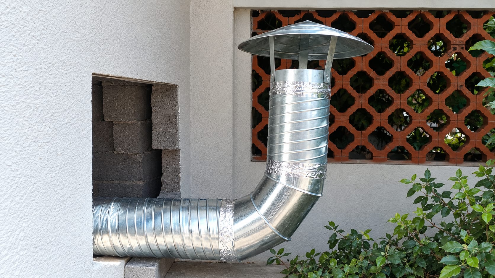 Extraction ducting routed through the basement wall to an external roof-cap outlet at the Paulshof property